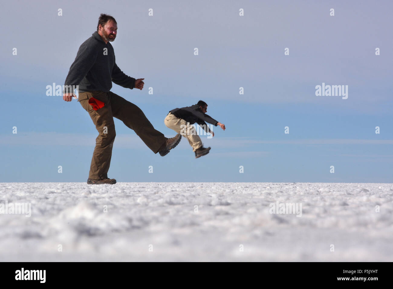 Optical illusion, man being kicked, Salar de Uyuni, Bolivia Stock Photo