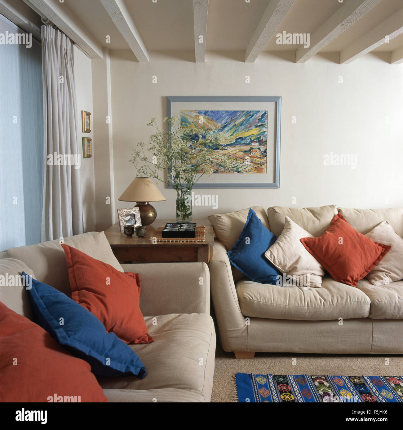 https://c8.alamy.com/comp/F5JYK6/blue-and-red-cushions-on-cream-sofas-in-a-traditional-living-room-F5JYK6.jpg