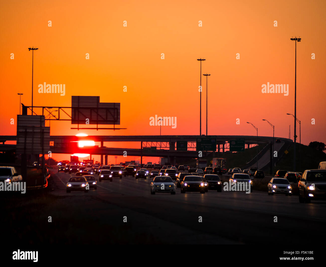 It's a long day fighting traffic to  get home after work. Bumper to bumper traffic on a major freeway as the sun sets in the West. Stock Photo