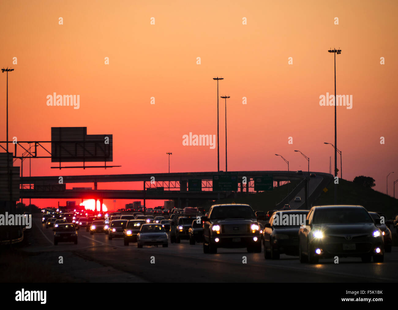 It's a long day fighting traffic to  get home after work. Bumper to bumper traffic on a major freeway as the sun sets in the West. Stock Photo