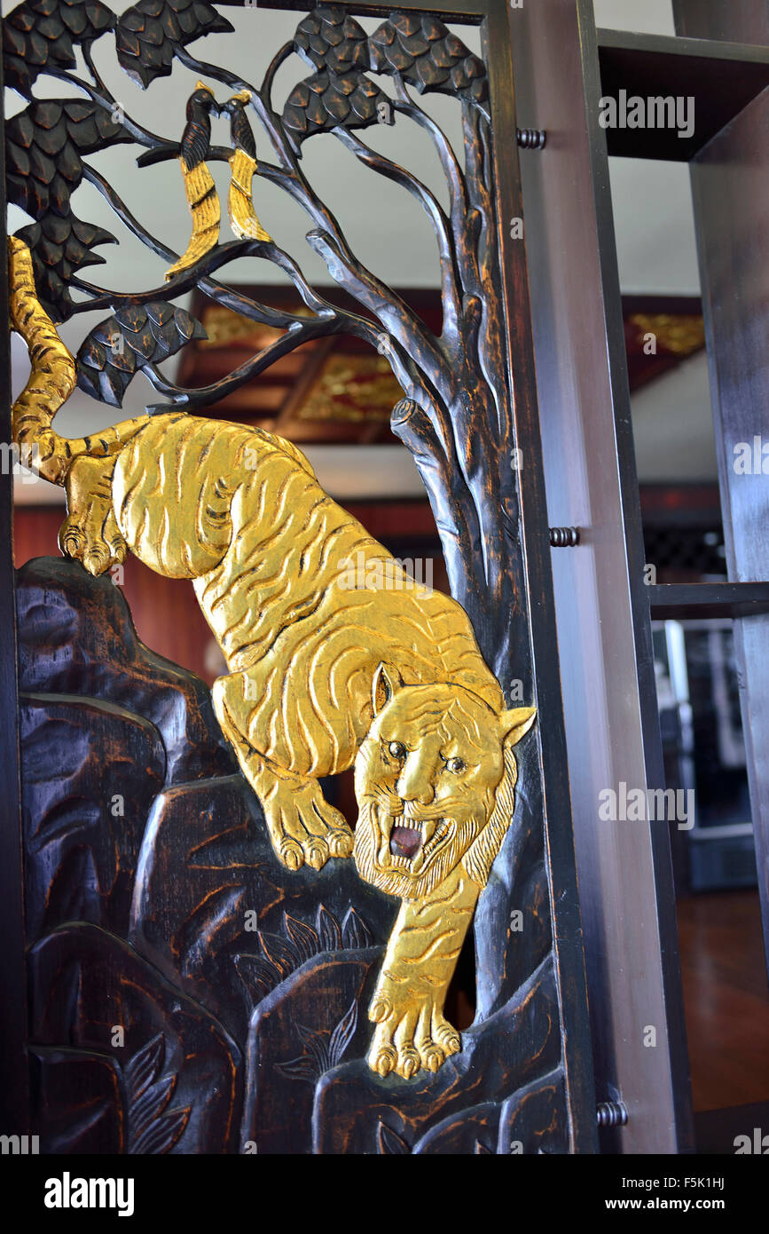 Ornate traditionally carved dinning room entrance doors with a tiger motive on RV Paukan Ayeyarwaddy River cruise Myanmar, Stock Photo