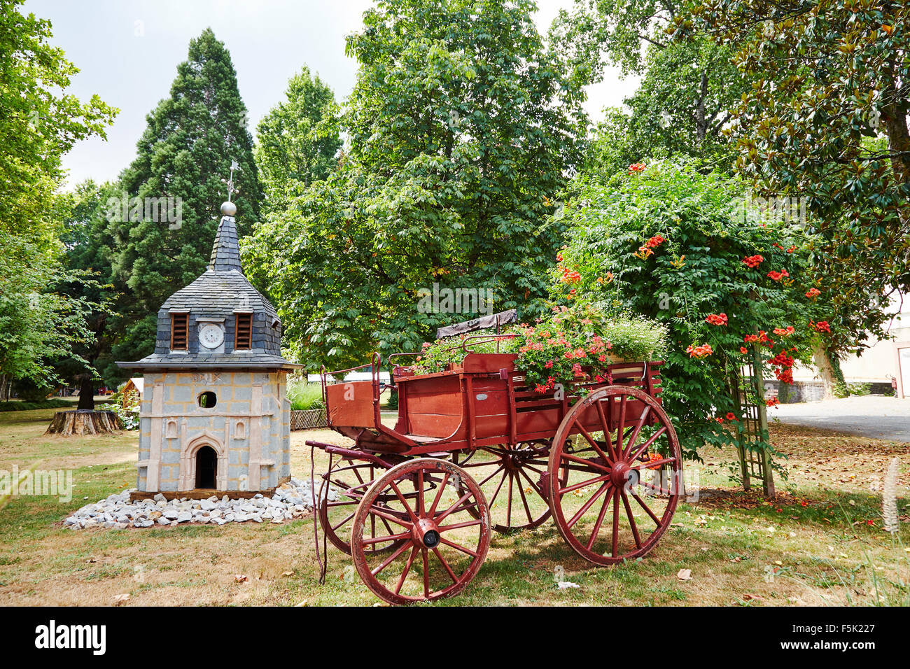 Decorative old cart and model of the church in a park in Objat, Limousin, Correze, France. Stock Photo