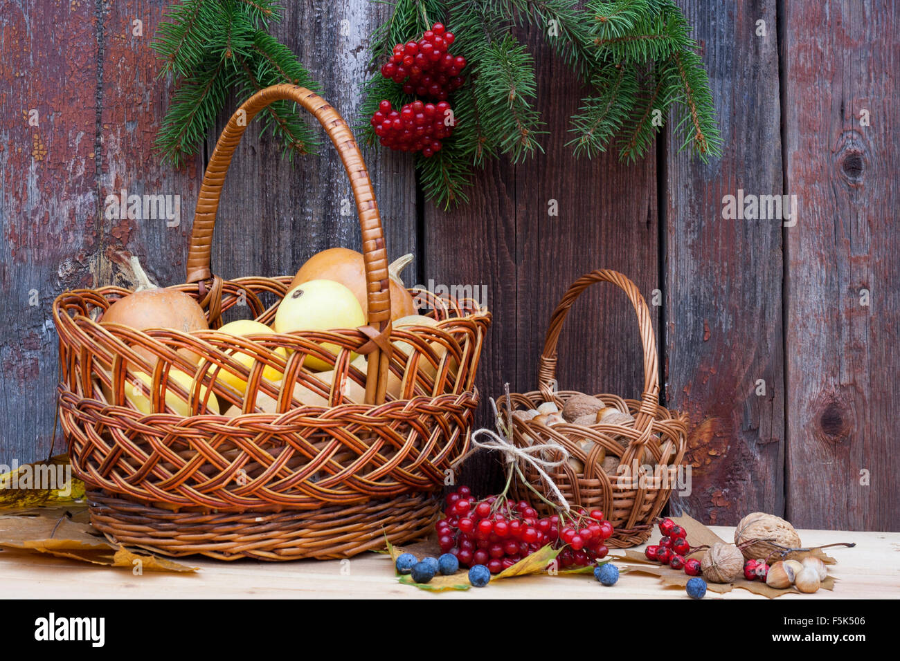 Autumn still life with pumpkins in basket and autumn berry on old ...