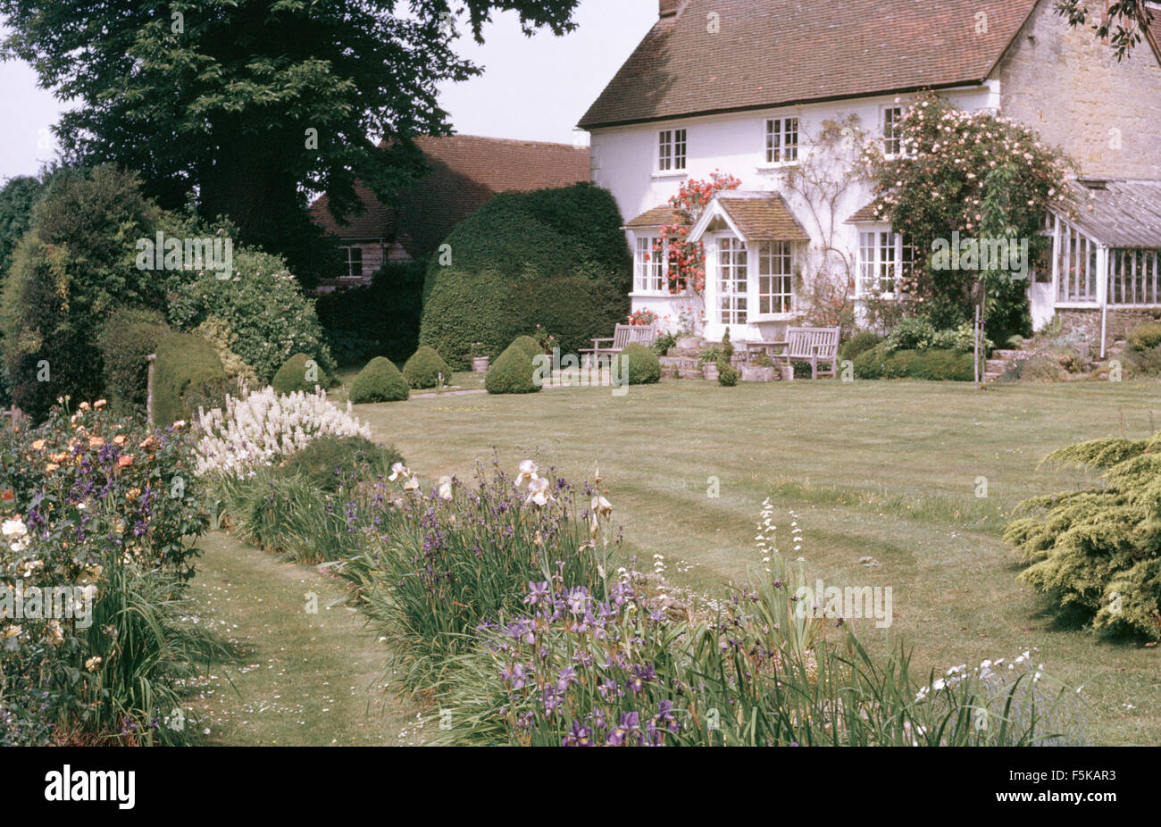 Exterior of country house with clipped box balls edging the lawn Stock Photo