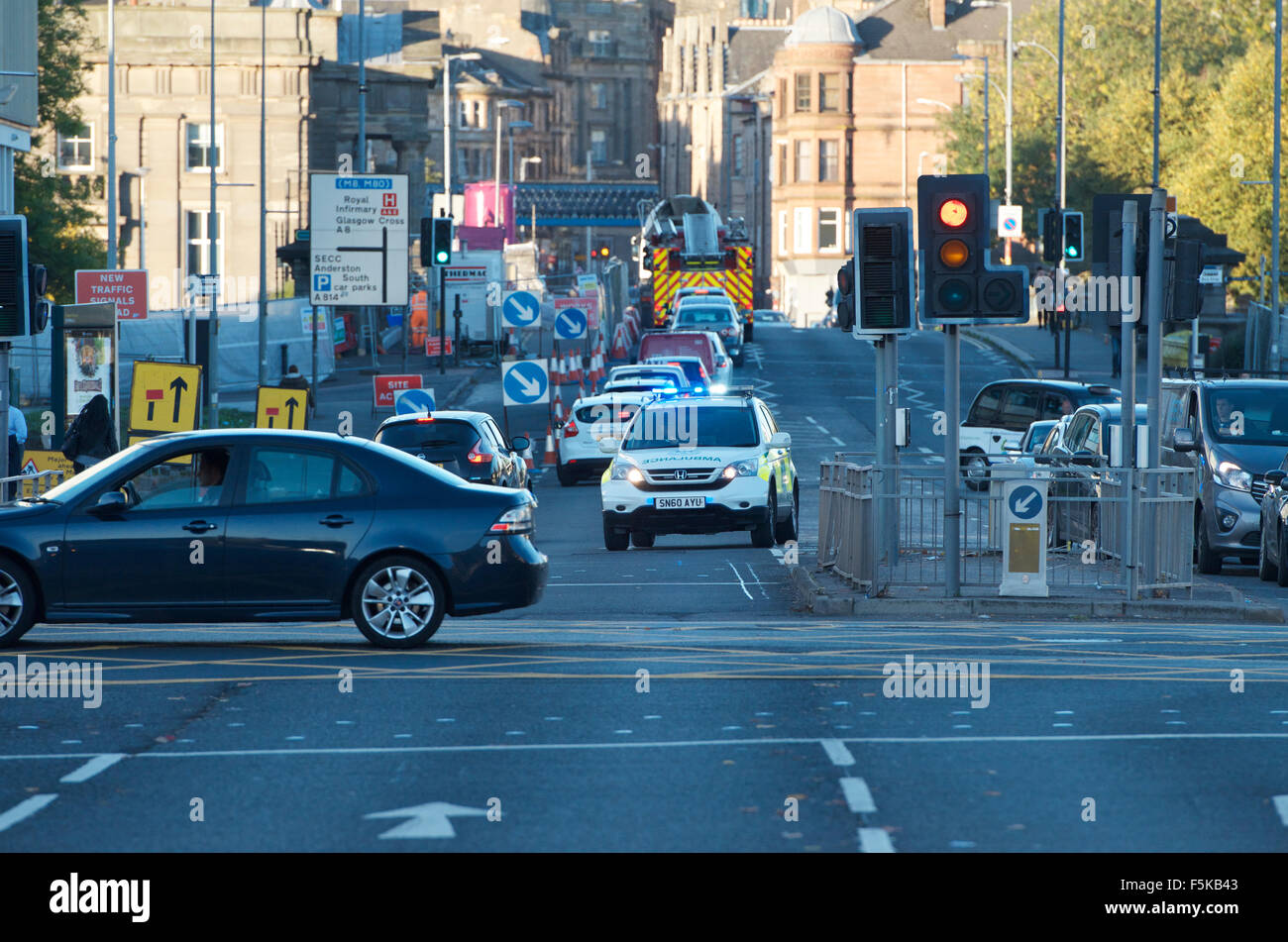Ambulance negotiates a traffic junction on an emergency call out. Stock Photo