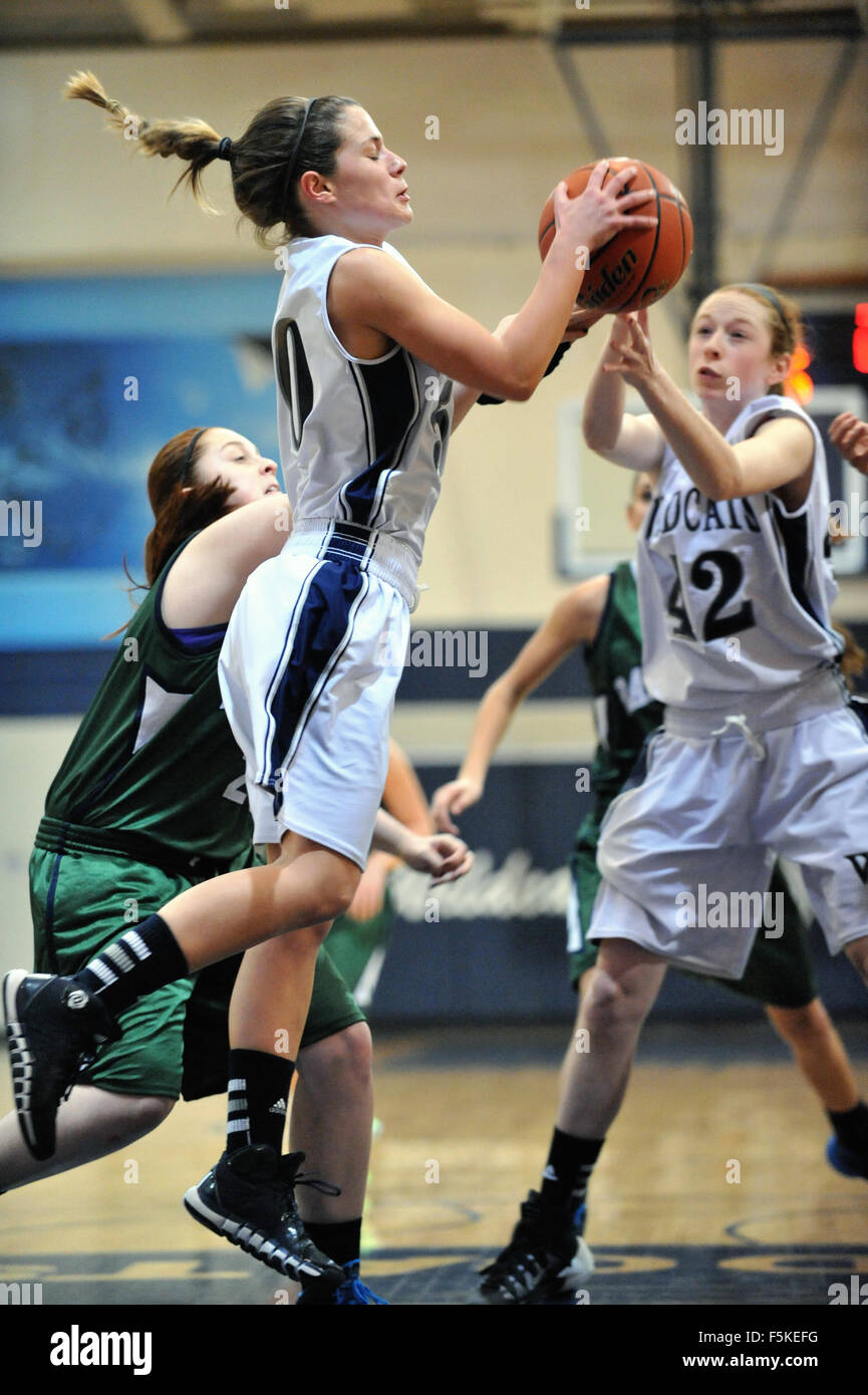 Player secures a rebound off her own boards during a high school basketball game. USA. Stock Photo