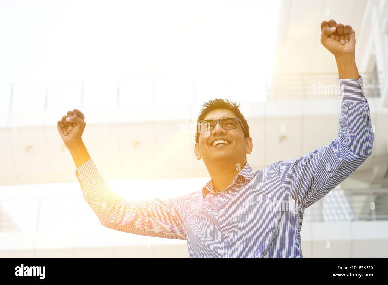 Successful Asian Indian businessman with arms up celebrating his ...