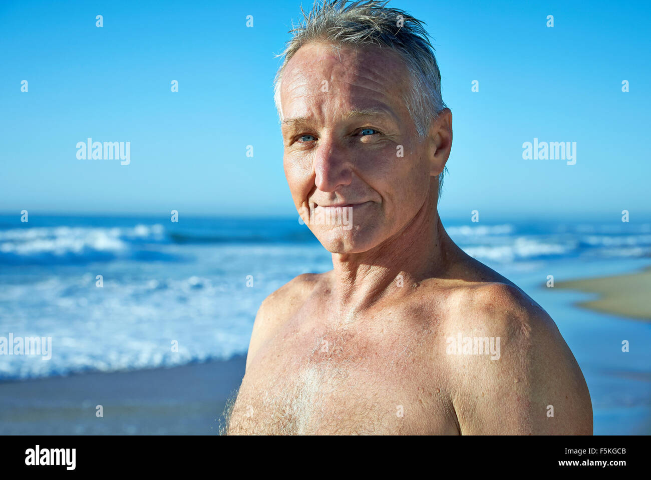 Head and shoulder portrait of a mature aged man with beach foreshore background Stock Photo