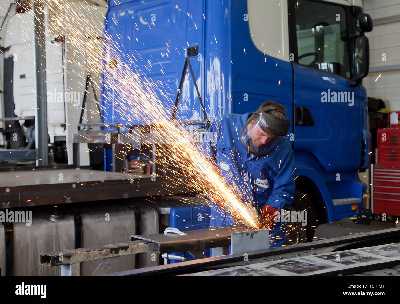 Man Welding lorry sparks in full PPE with gloves and visor Stock Photo