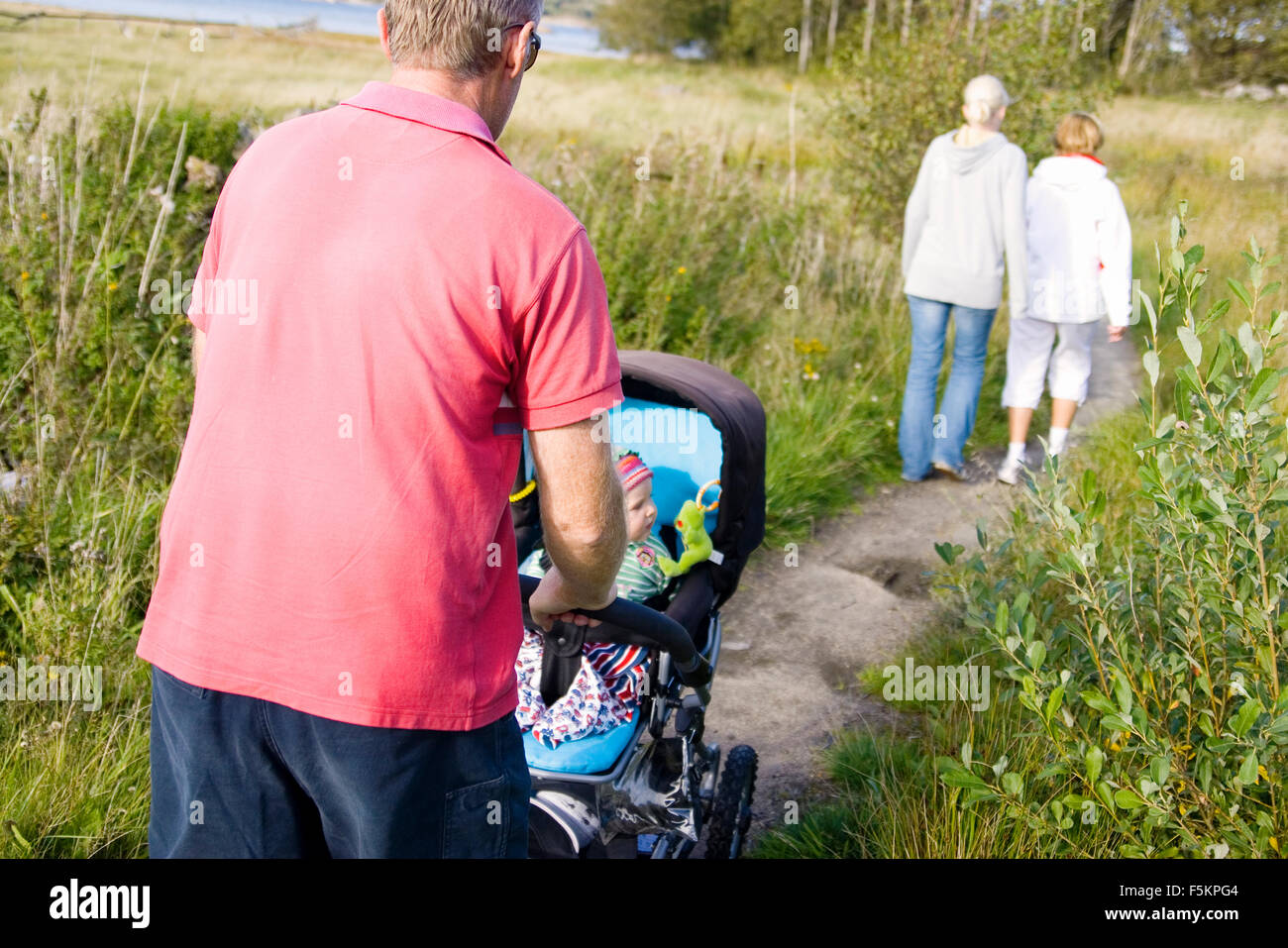 Sweden, Bohuslan, Tjorn, Family on walk with baby (18-23 months) in rural area Stock Photo