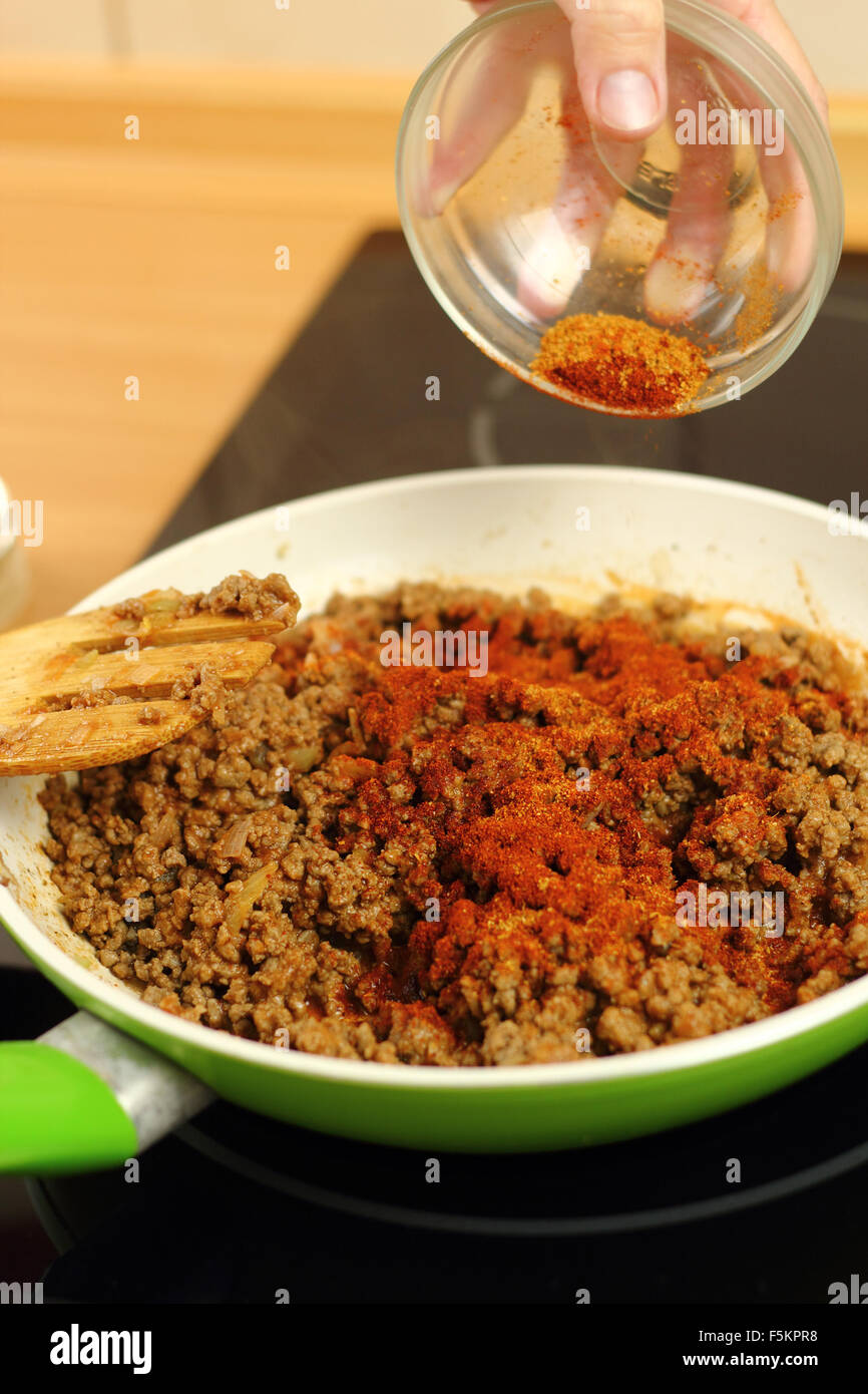 Adding mix spices into ground beef. Making enchilada tortilla with beef