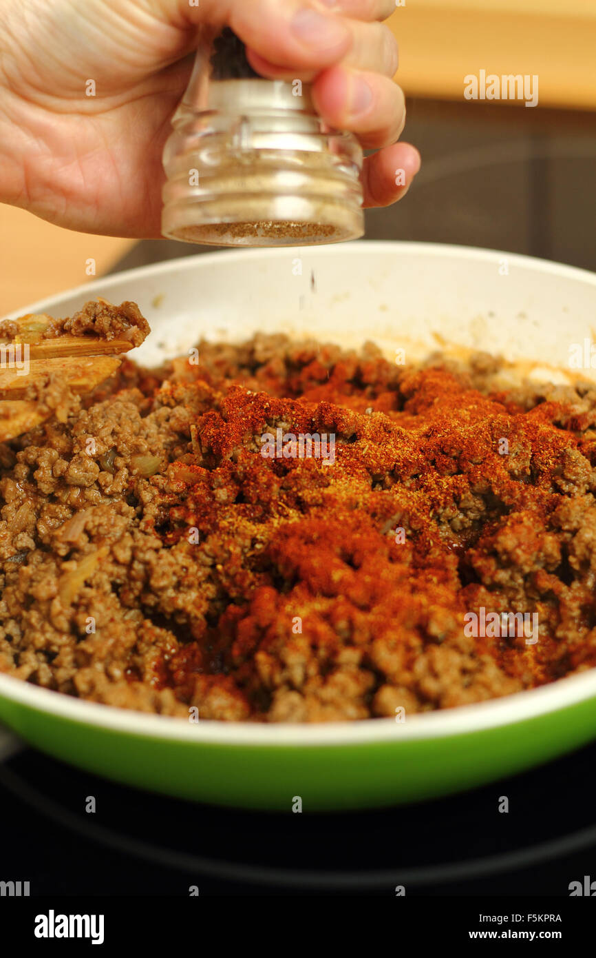 Adding mix spices into ground beef. Making enchilada tortilla with beef