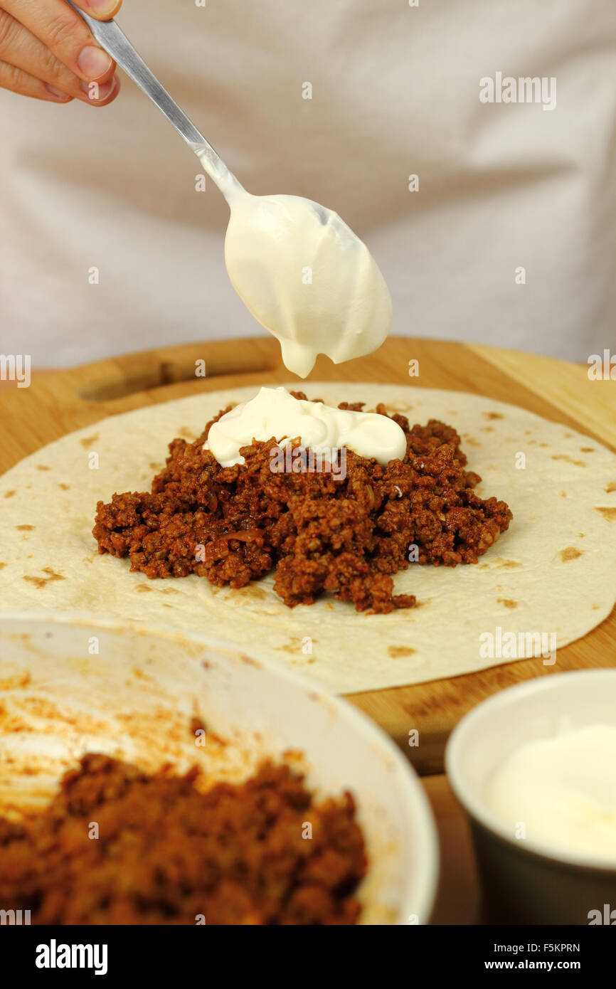 Adding tablespoon of sour cream into stuffing (ground beef). Making