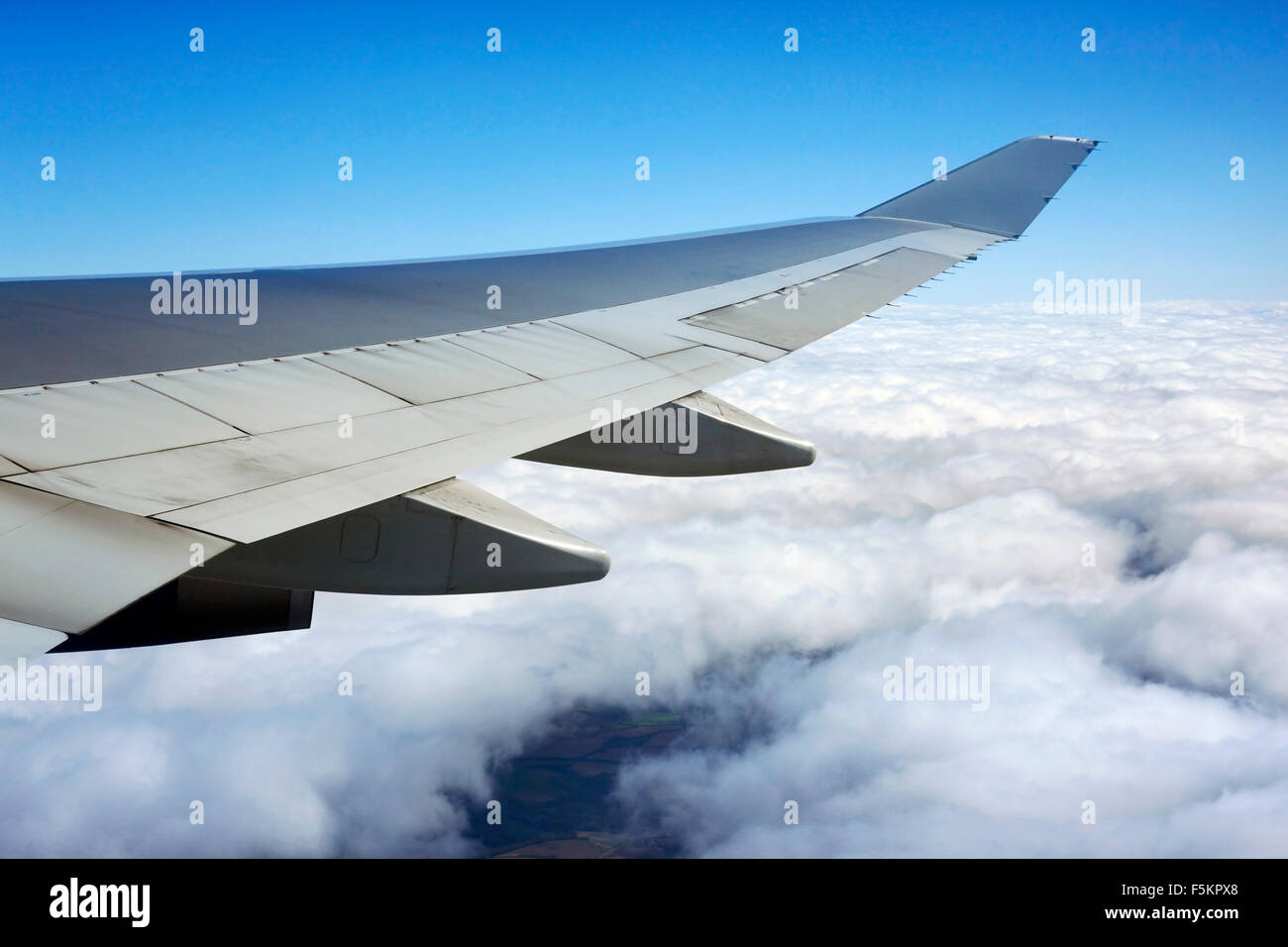 Wing of the plane on a background of clouds Stock Photo
