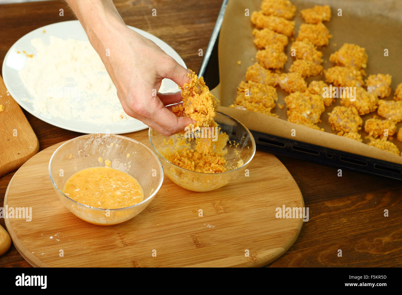 Freshly breaded in corn flakes chicken fillet. Making oven baked corn