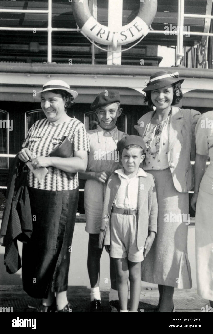 Two women with two children embark on a ship, Italy Stock Photo