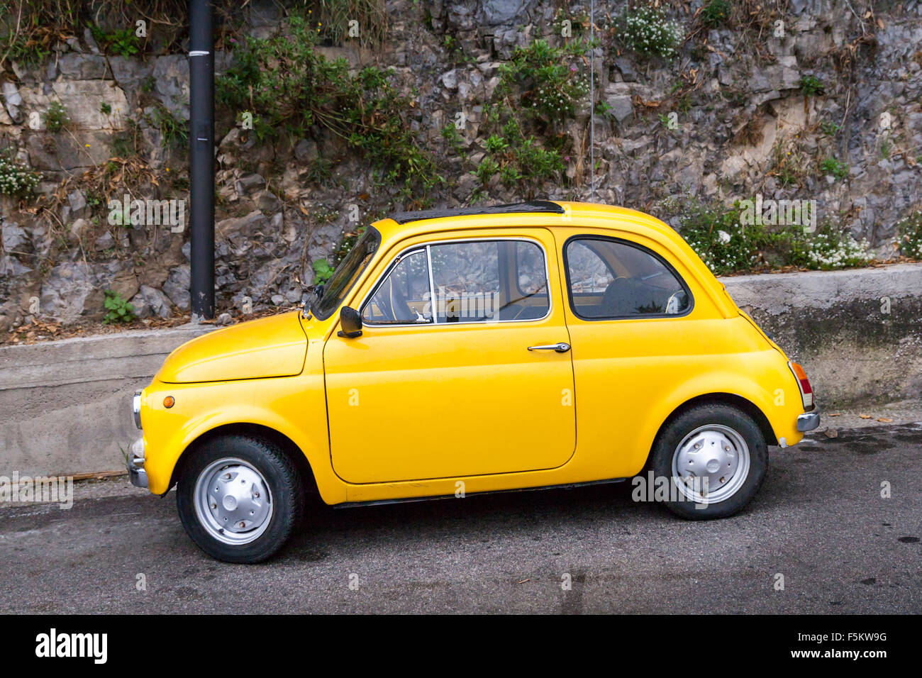 Yellow Fiat 500 Cinquecento parked in a street on the Amalfi Coast, Campania, Mediterranean, Italy Stock Photo