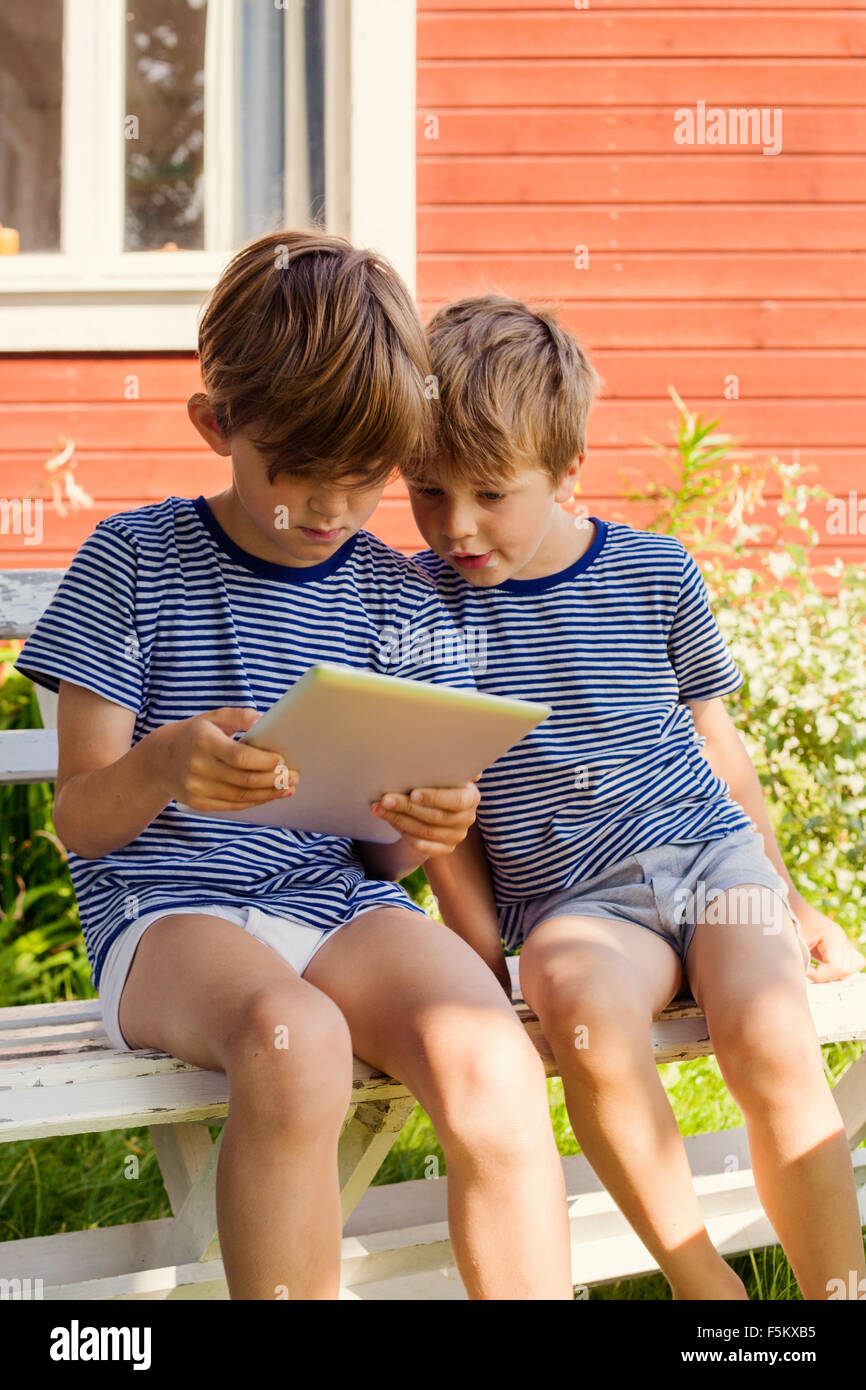 Sweden, Halsingland, Jarvso, Brothers (4-5, 6-7) using digital tablet Stock Photo