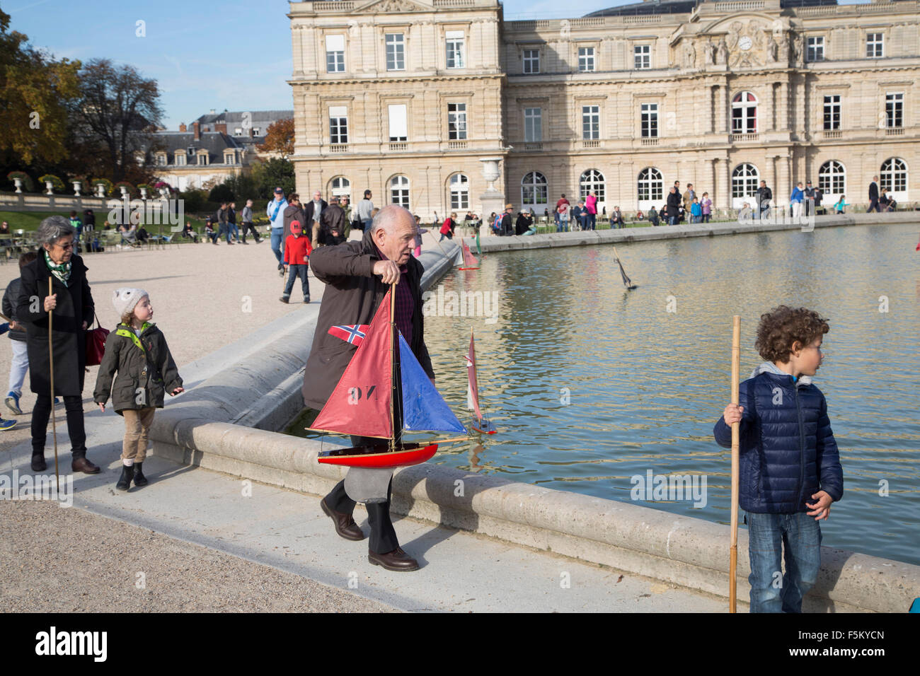 family playing with model yachts in jardin du luxembourg, paris france Stock Photo