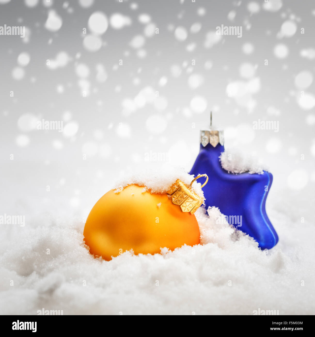 Christmas decoration. Gold ball and blue star on abstract snow background Stock Photo