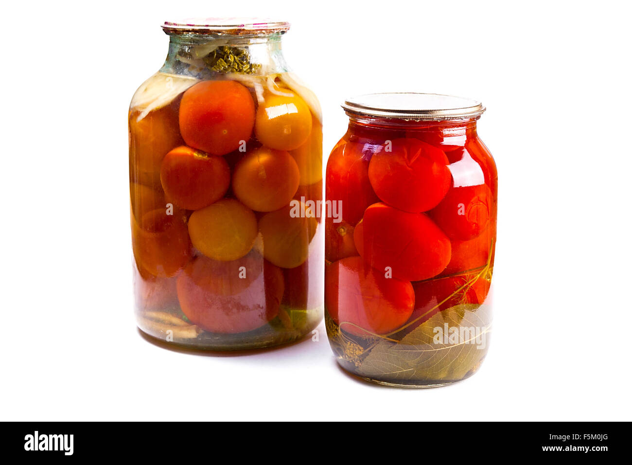 Tomatoes vegetables canned in glass jar isolated on white background