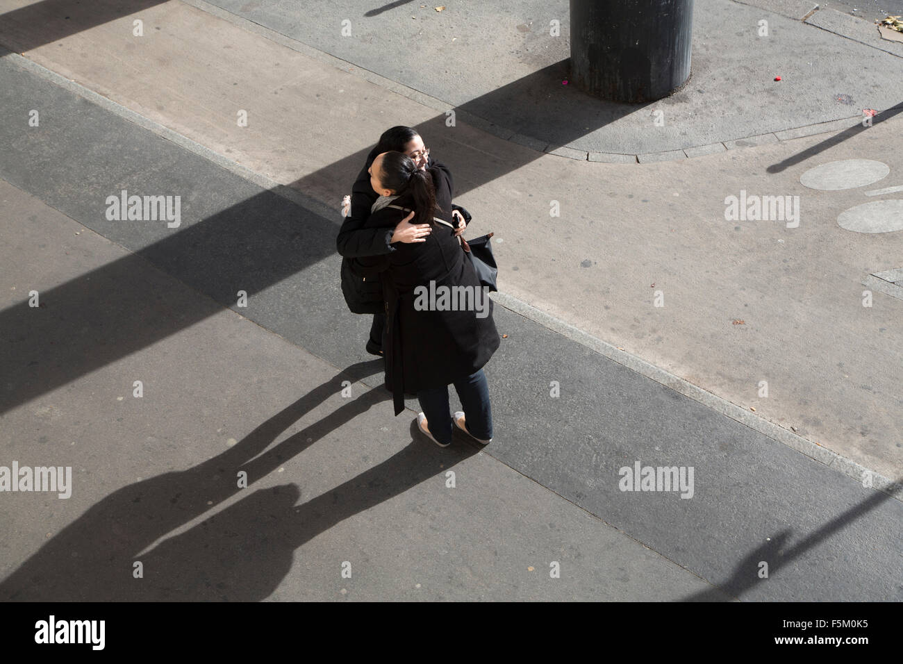young women embrace on sunny street Stock Photo