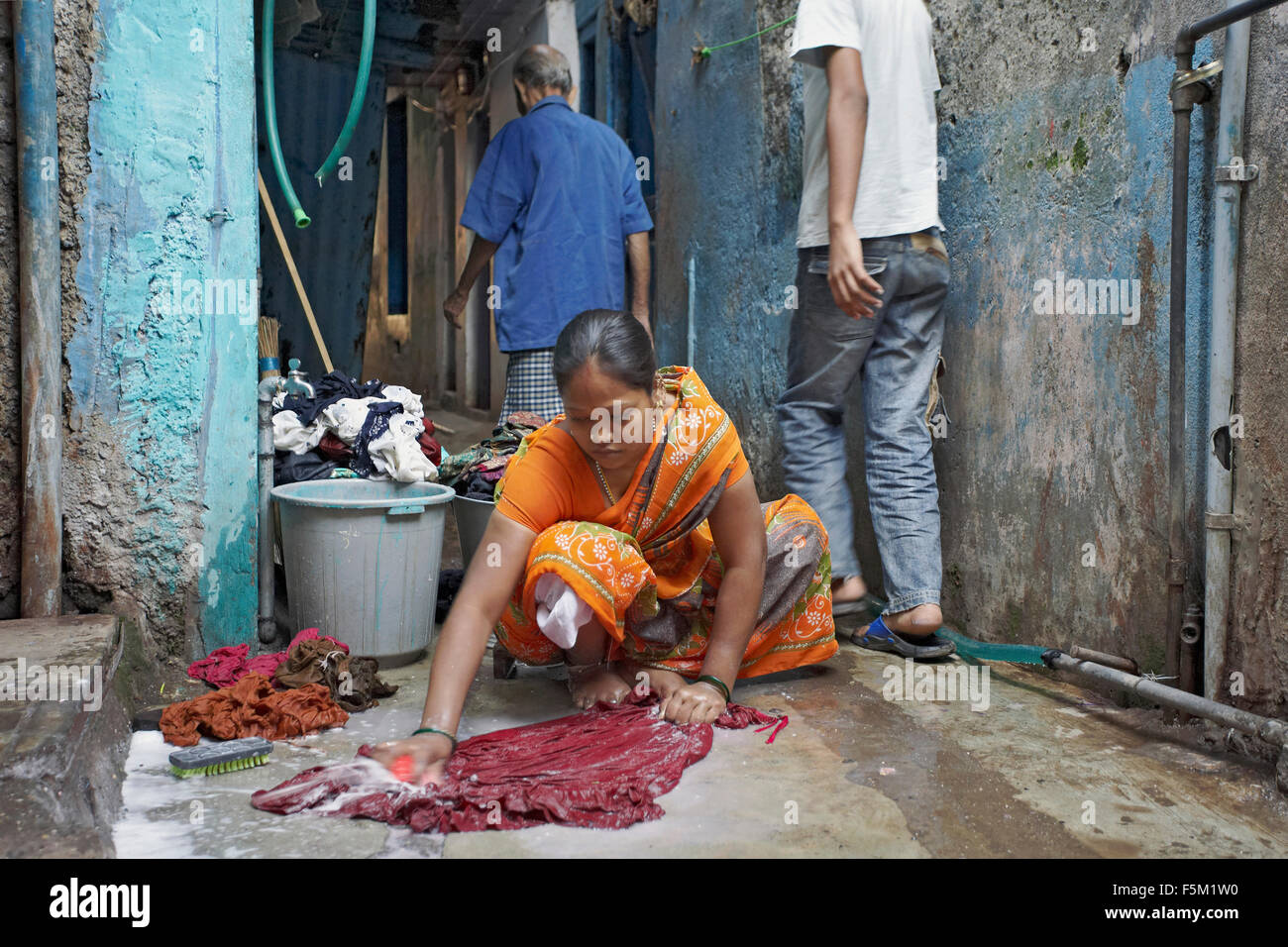 Woman washing clothes in narrow lane, mumbai, maharashtra, india, asia Stock Photo