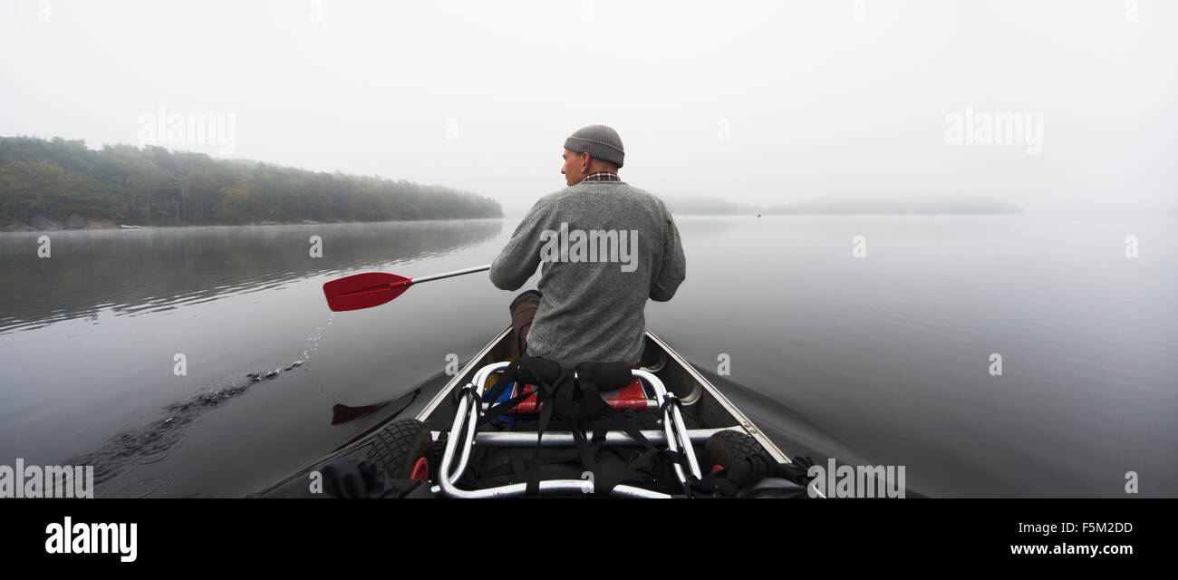 Sweden, Blekinge, Lake Halen, Man rowing on lake Stock Photo