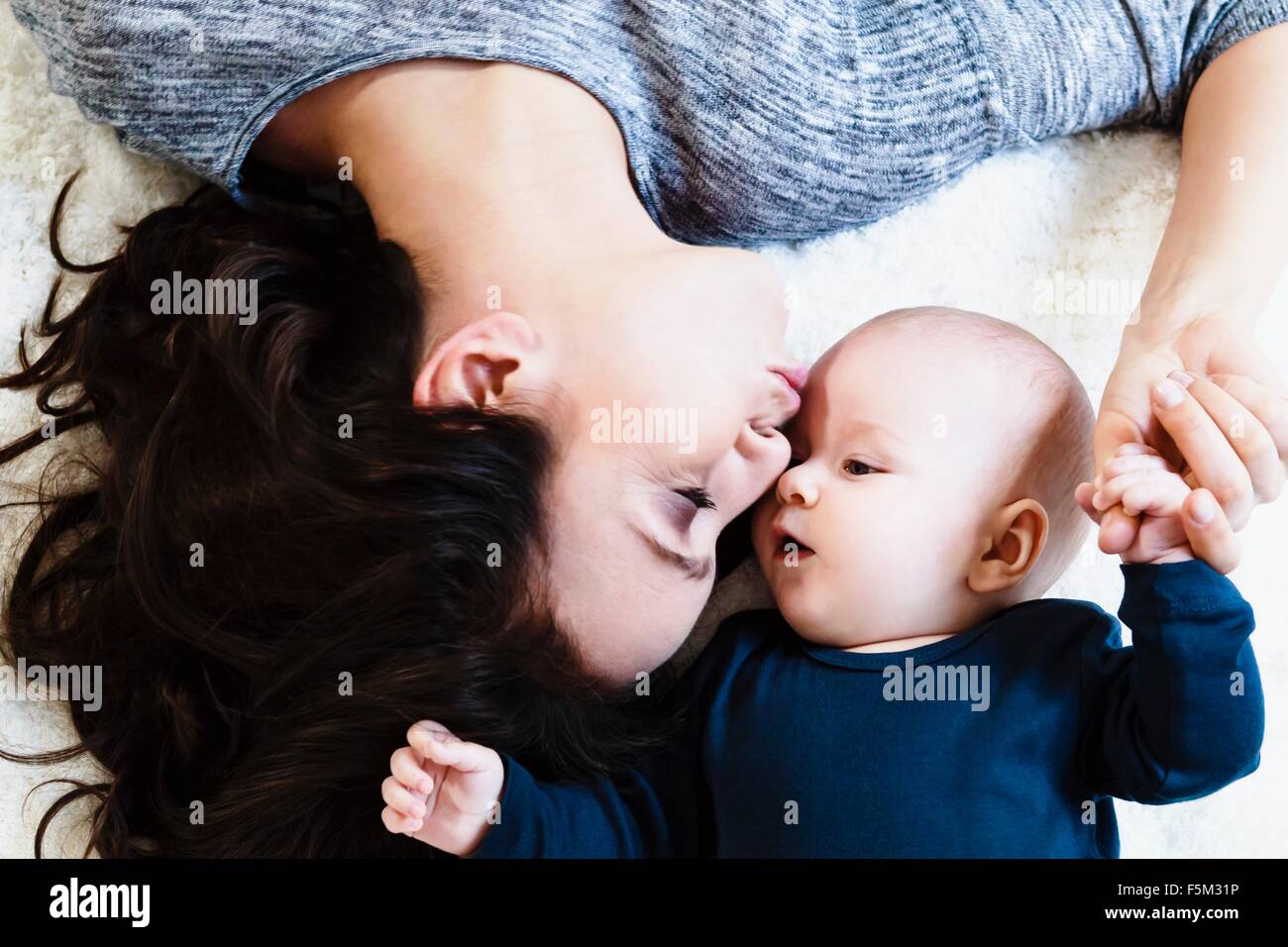 Overhead view, mother kissing baby boy on forehead Stock Photo