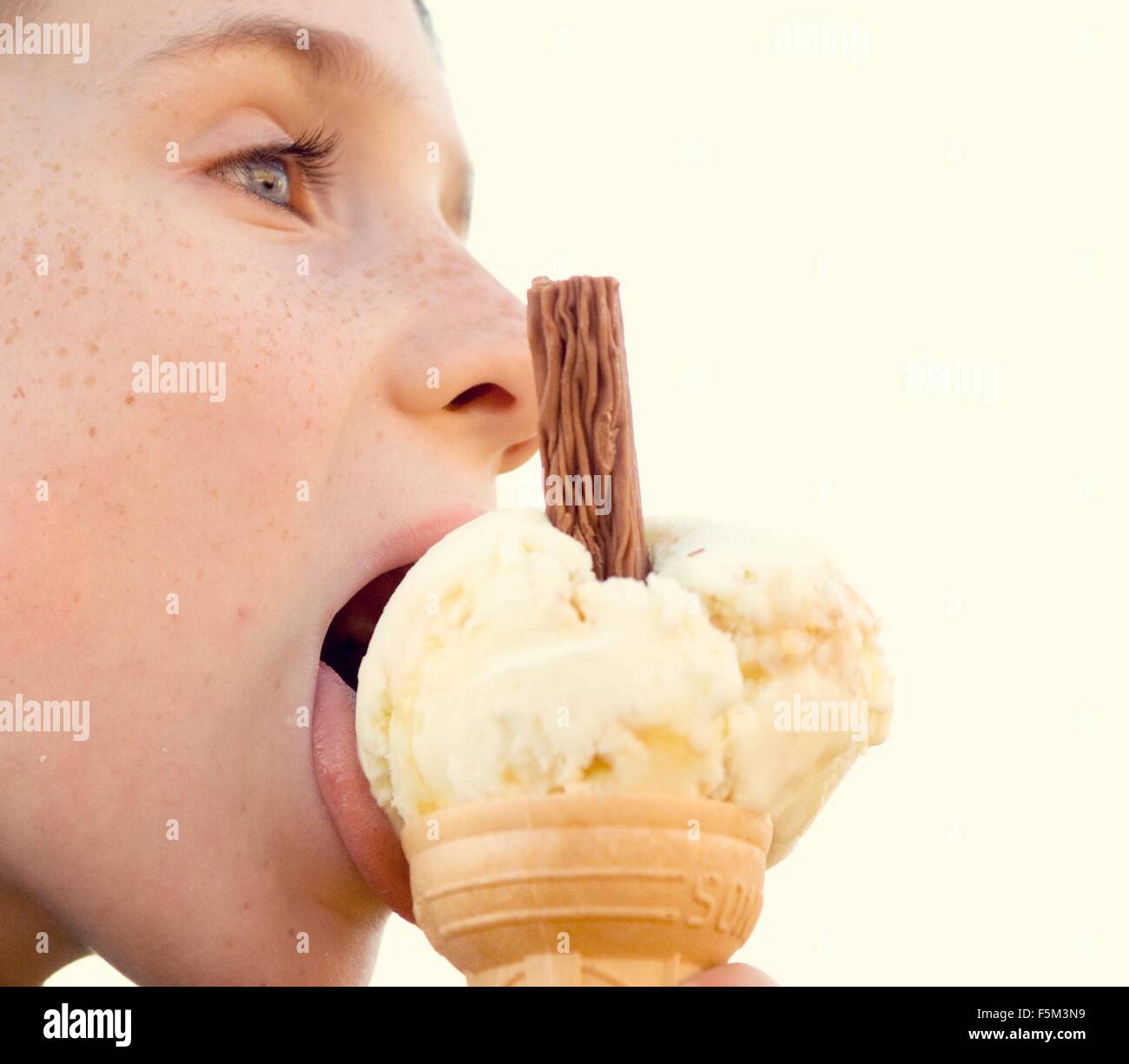 Side view close up of boy licking ice cream cone Stock Photo