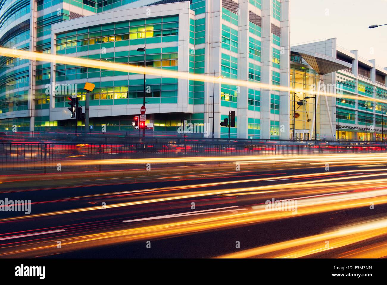 Traffic light trails and office building at dusk, London, UK Stock Photo