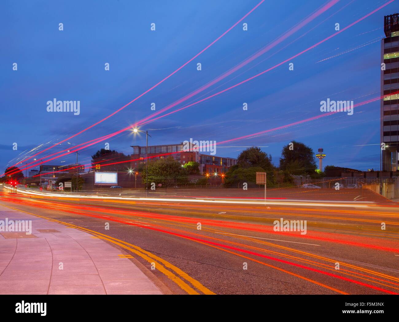 Highway traffic light trails from roadside at dusk Stock Photo