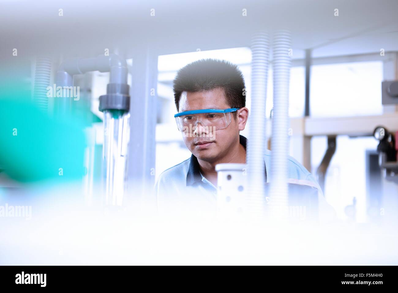 Man wearing safety goggles in flexible electronics plant Stock Photo