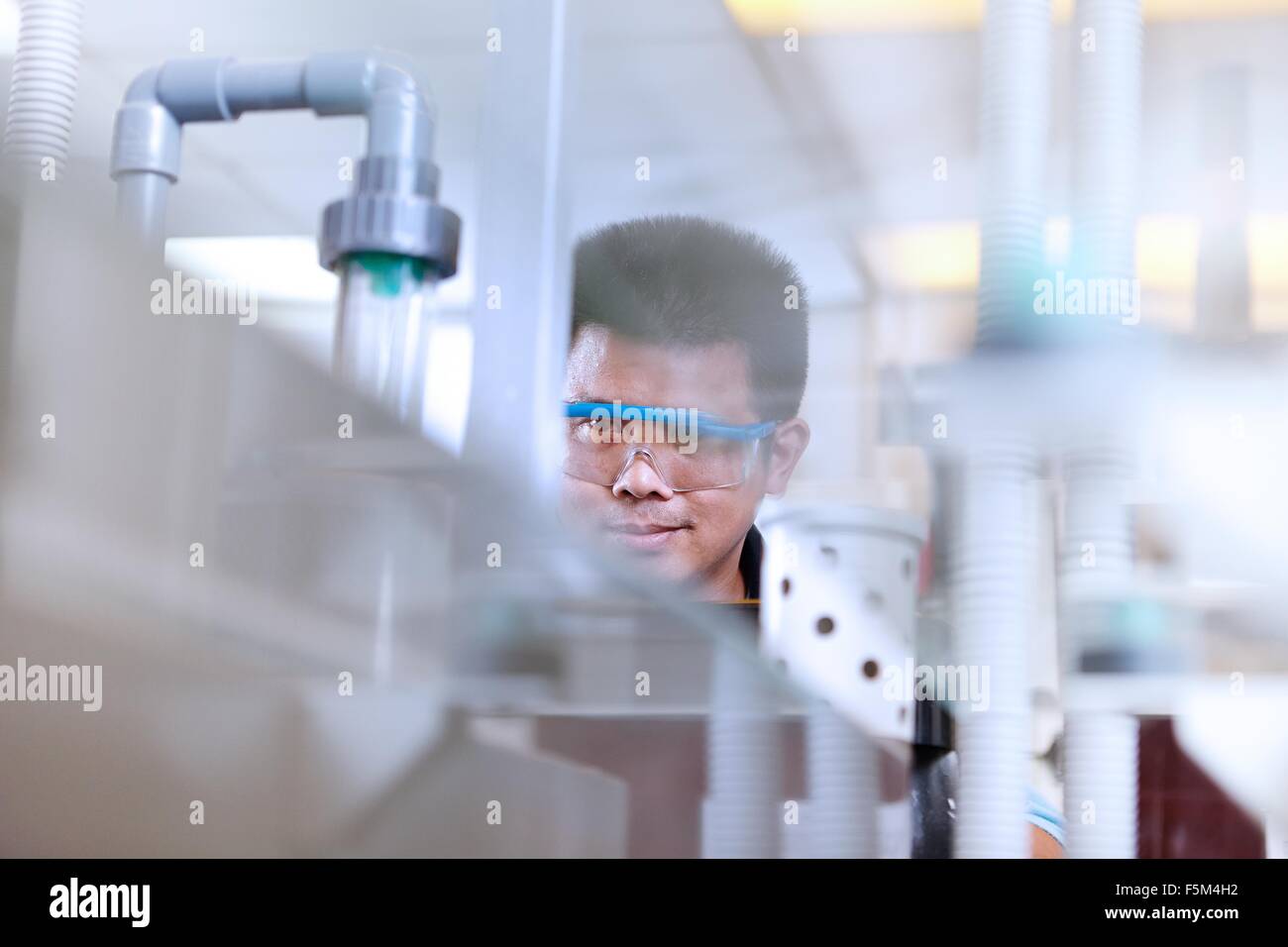 Man wearing safety goggles in flexible electronics plant Stock Photo