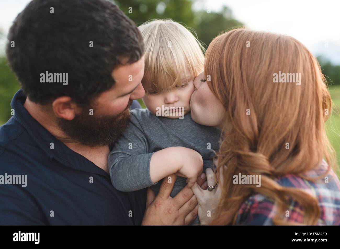 Mother and father holding young son, outdoors Stock Photo
