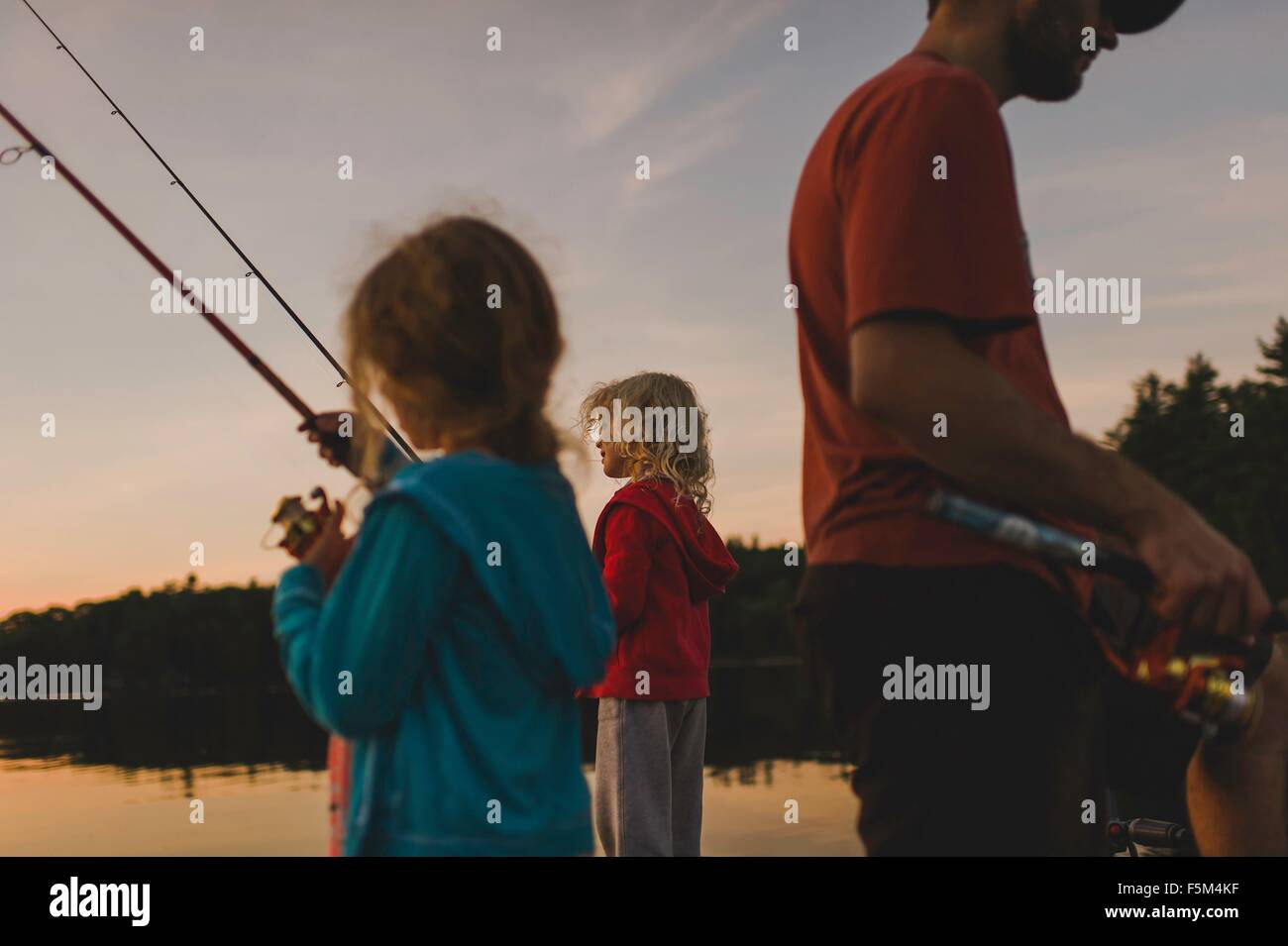 Father and daughters fishing, Kings Lake, Ontario, Canada Stock Photo