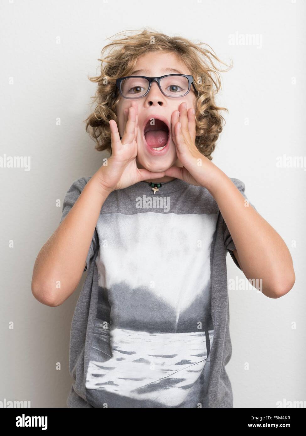 Boy shouting with hands cupping mouth Stock Photo