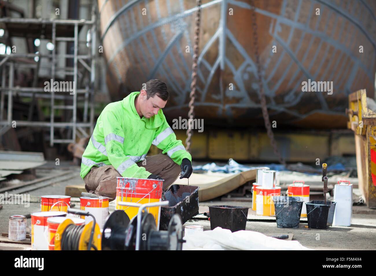 Worker mixing boat paints in shipyard Stock Photo