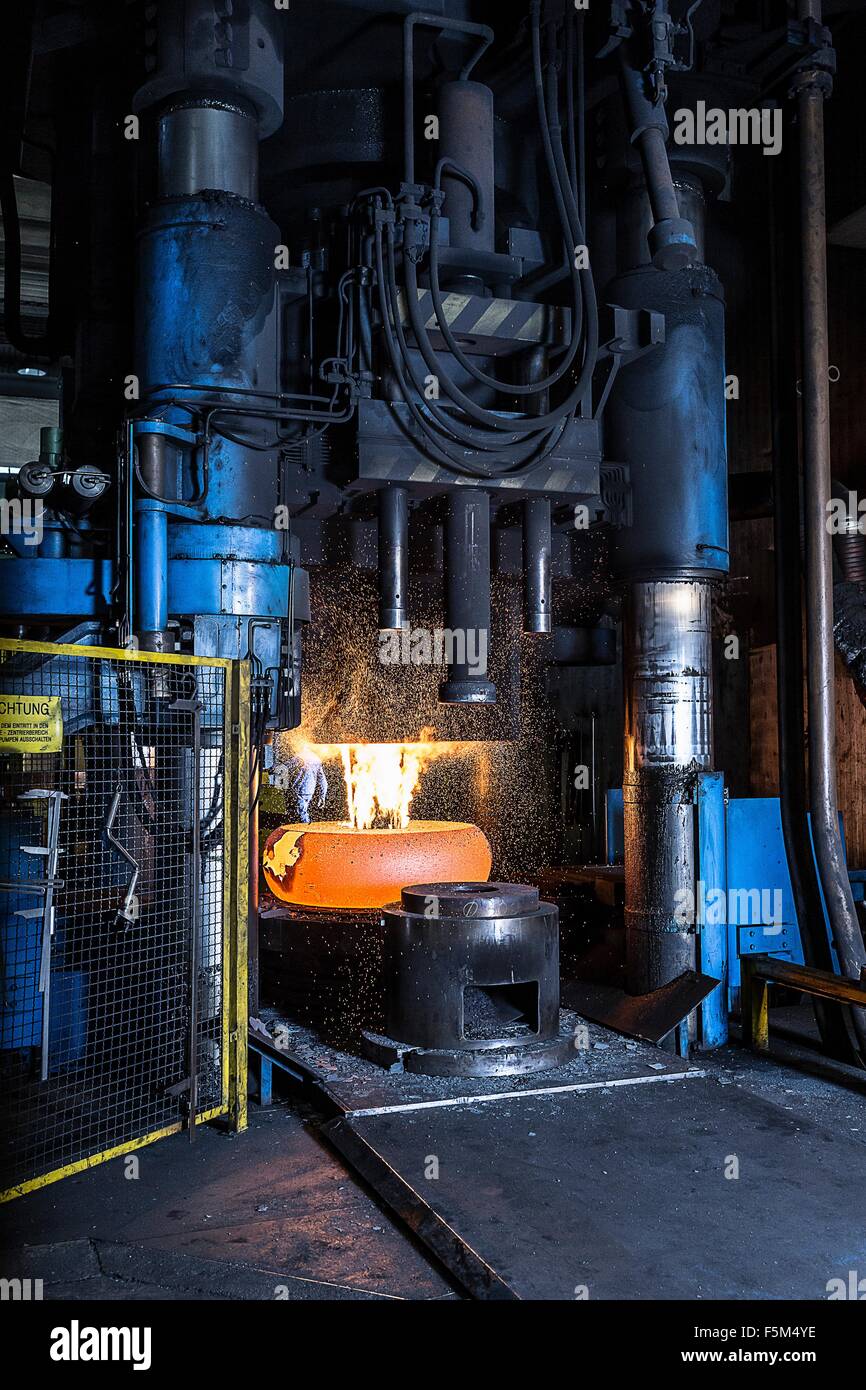 Manufacturing machine shaping red hot steel in foundry Stock Photo