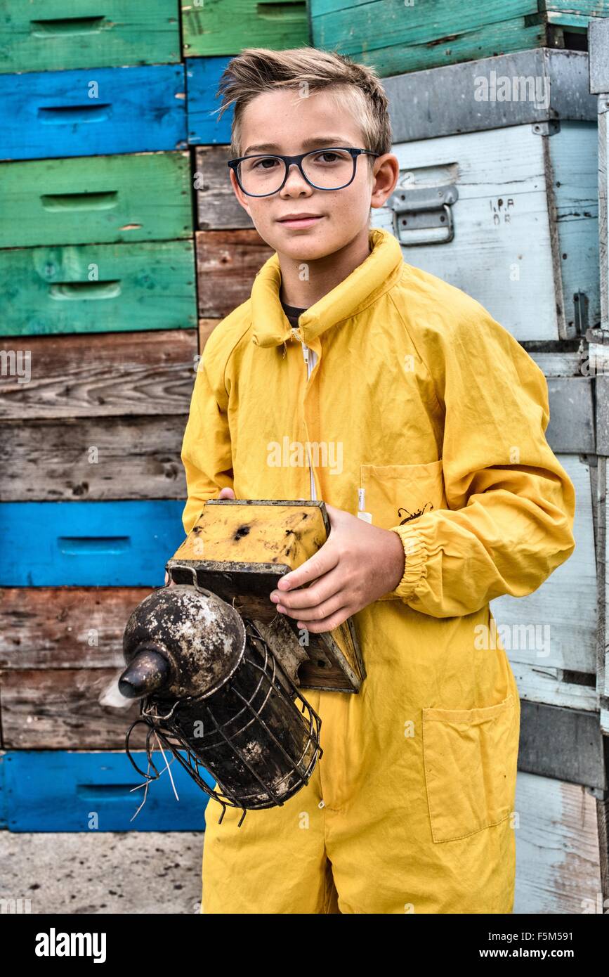 Portrait of young boy wearing beekeeper dress holding a bee smoker Stock Photo