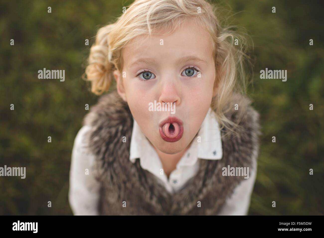 Portrait of young girl, curling tongue Stock Photo