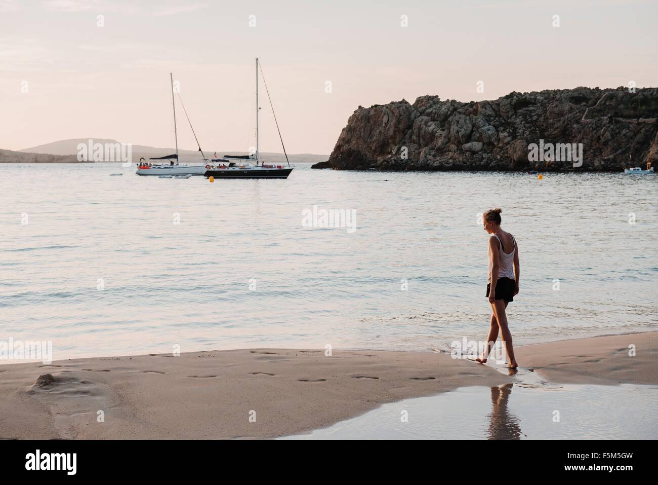 Mid adult woman strolling on beach, Menorca, Balearic islands, Spain Stock Photo
