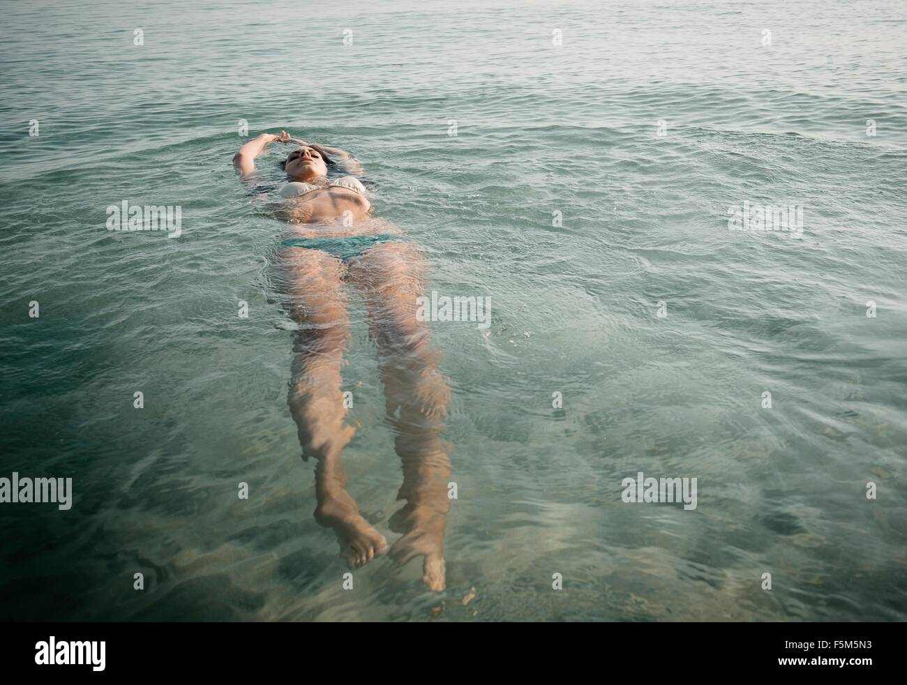 Young woman wearing bikini floating in sea Stock Photo
