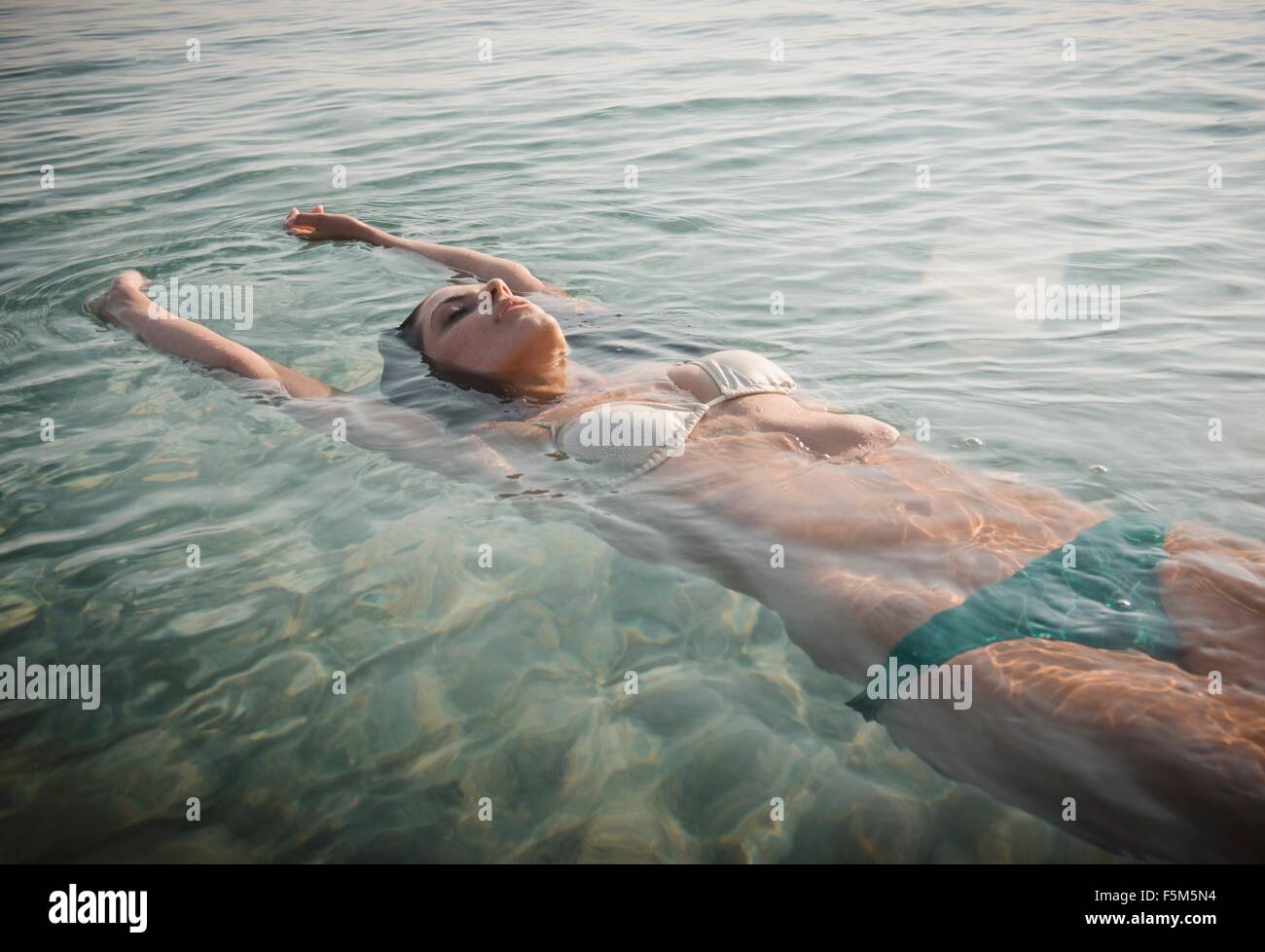 Young woman wearing bikini floating in sea Stock Photo