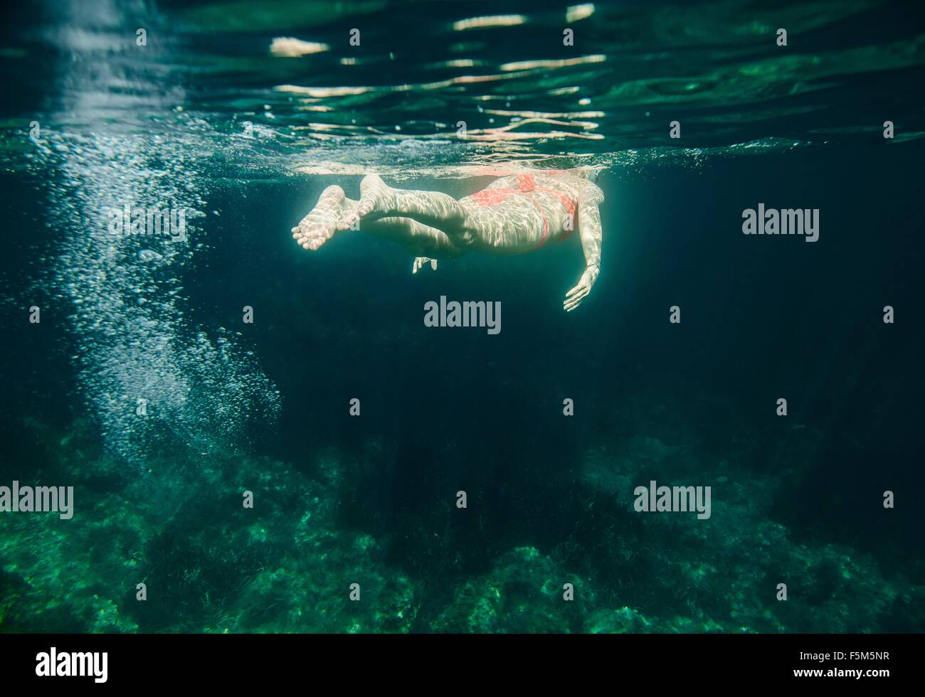 Underwater view of woman swimming, Menorca, Balearic islands, Spain Stock Photo
