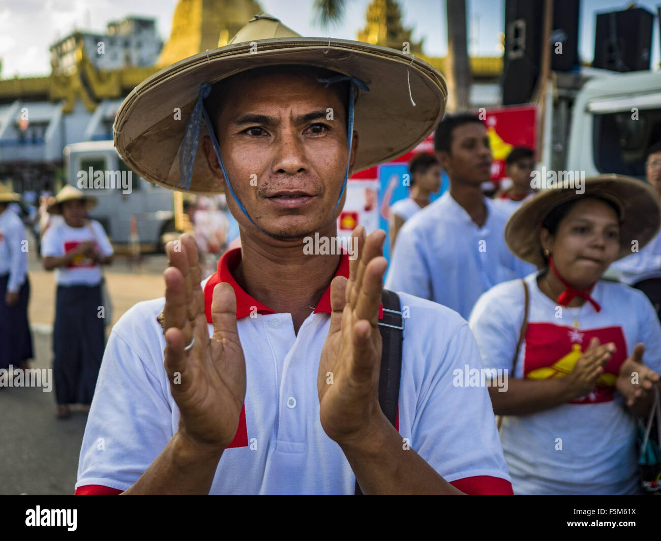 Yangon, Yangon Division, Myanmar. 6th Nov, 2015. A man applauds the speakers at the final NDF election rally of the 2015 election. The rally was held in central Yangon, next to the historic Sule Pagoda and across the street from Yangon city hall. The National Democratic Force (NDF) was formed by former members of the National League for Democracy (NLD) who chose to contest the 2010 general election in Myanmar because the NLD boycotted that election. There have been mass defections from the NFD this year because many of the people who joined the NFD in 2010 have gone back to the NLD, which is Stock Photo