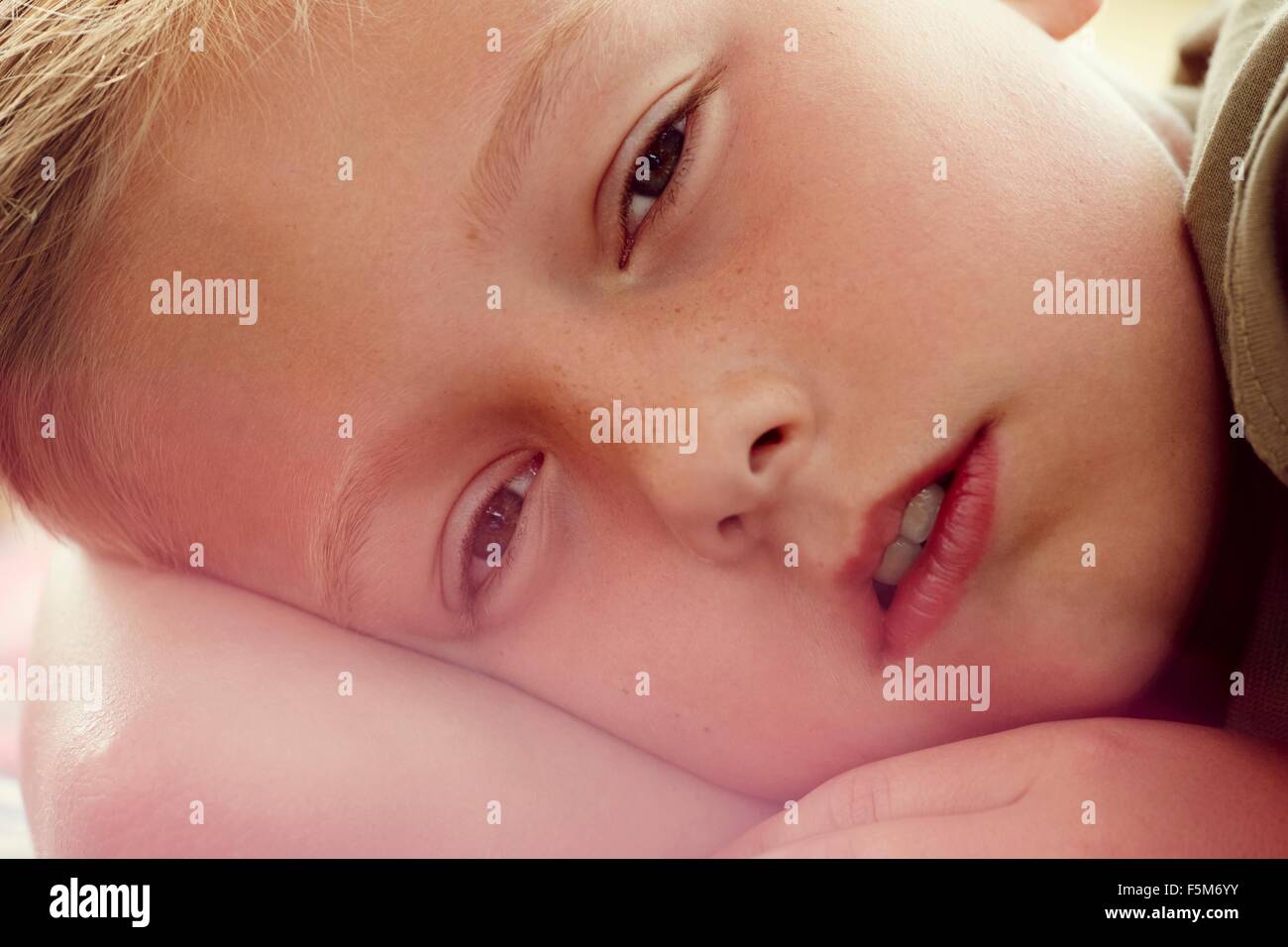 Close up portrait of boy lying down looking at camera Stock Photo