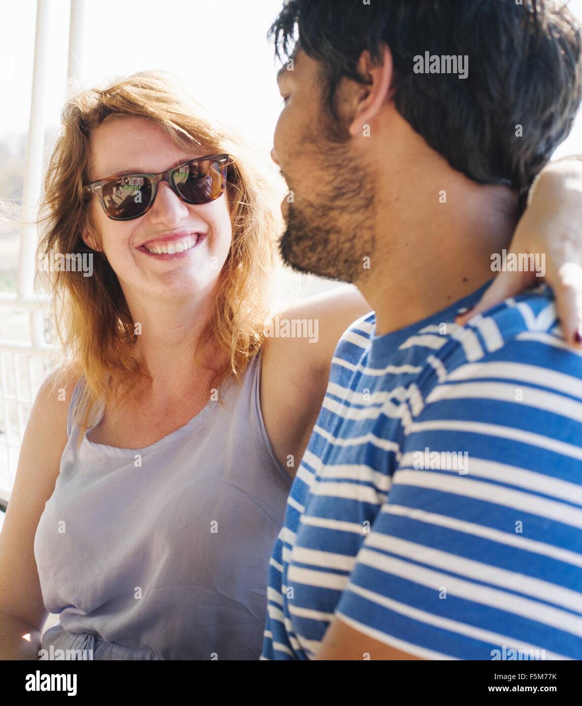Portrait of young woman with arm around boyfriend Stock Photo