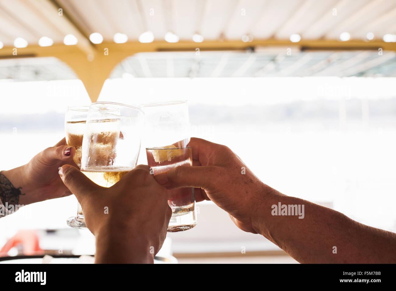 Three male and female hands making a toast with white wine Stock Photo
