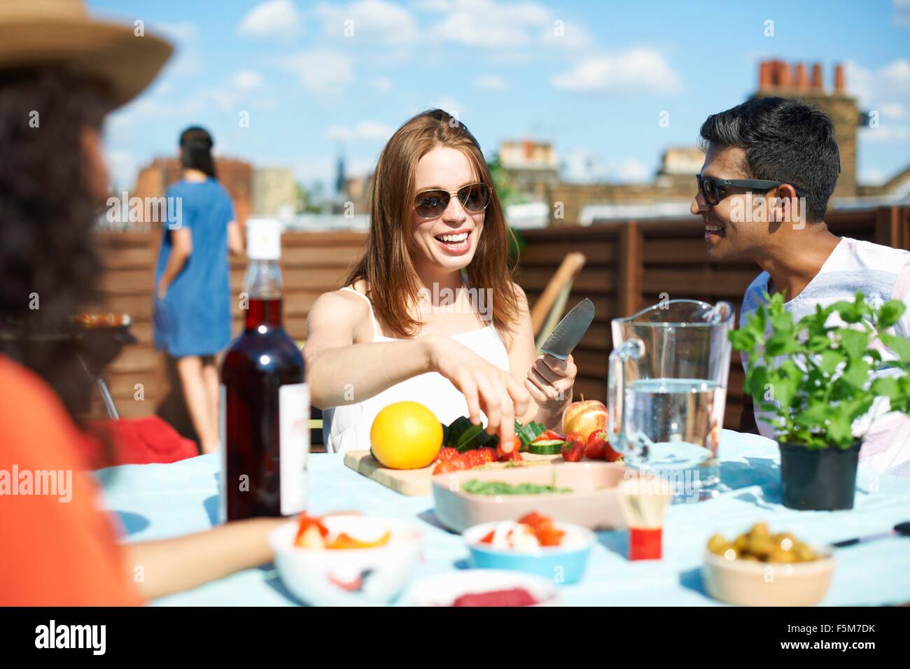 Adult friends preparing fresh finger food at rooftop party Stock Photo